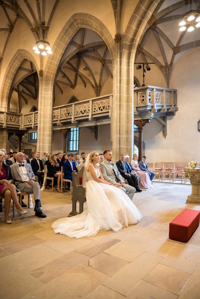 Hochzeit Karlsruhe – Zeremonie mit sitzenden Gästen Hochzeitszeremonie in Karlsruhe – Gäste sitzen während der Trauung, feierlicher Moment, gespannte Stimmung bei der freien oder kirchlichen
