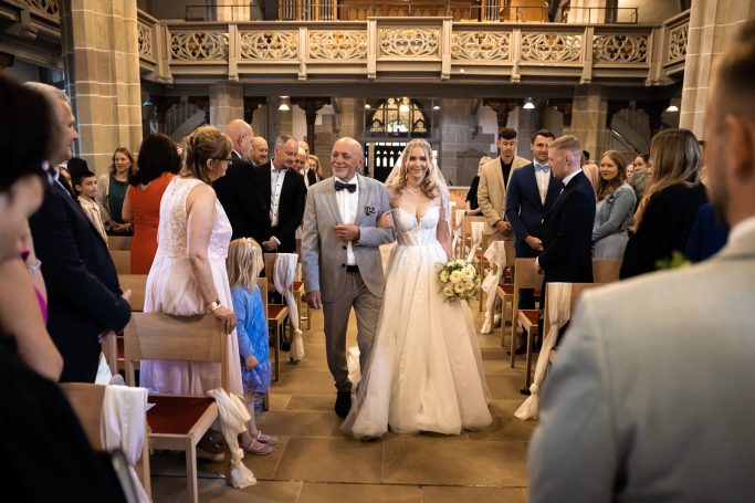 Hochzeit Stuttgart – Braut läuft mit Vater in die Kirche ein Rührender Moment: Braut läuft mit Vater in die Kirche ein und wird in Stuttgart dem Bräutigam übergeben – emotionale Hochzeit, feierlicher E
