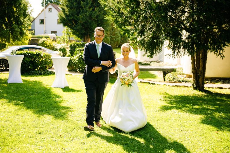 Doro läuft mit dem Bruder zur Trauung Der Bruder der Braut bringt die Braut zum Altar