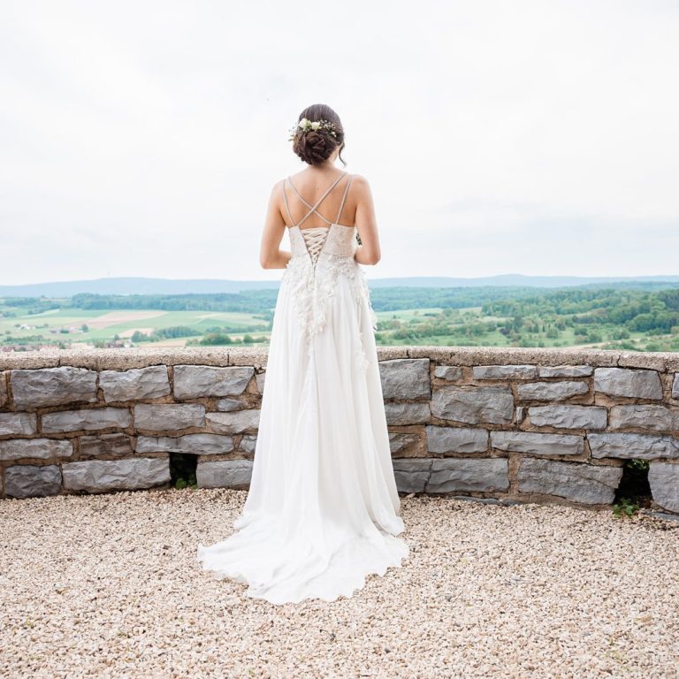 Fotograf macht Bild von Braut von hinten, währenddessen Schaut sie auf das Weinland Braut schaut auf das Weinland Heilbronn Hochzeitsfotografie