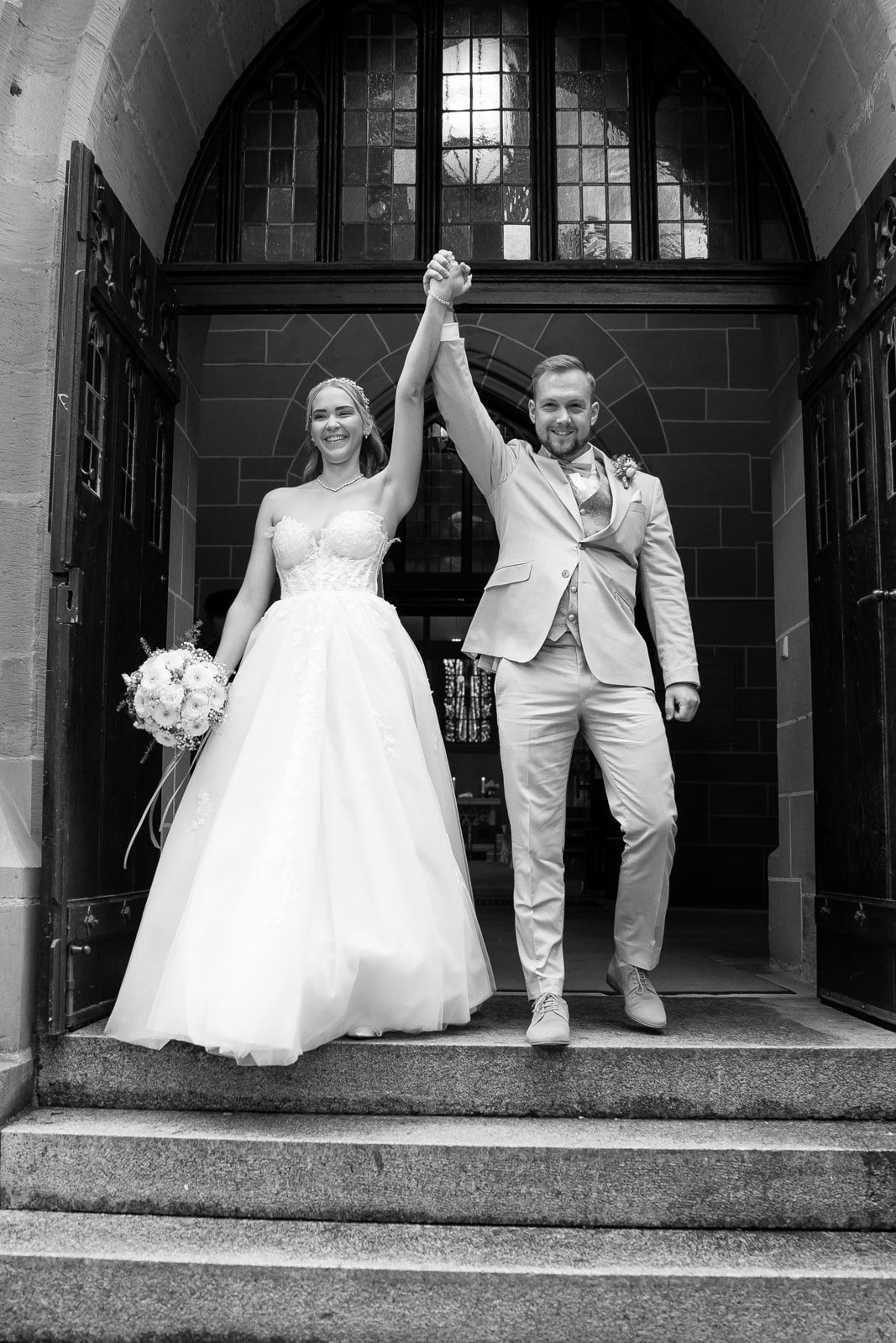 Frisch verheiratetes Brautpaar läuft Hand in Hand aus der Kirche. Hochzeitsfotograf Ludwigsburg und Heilbronn aufgenommenes Siegerbild.