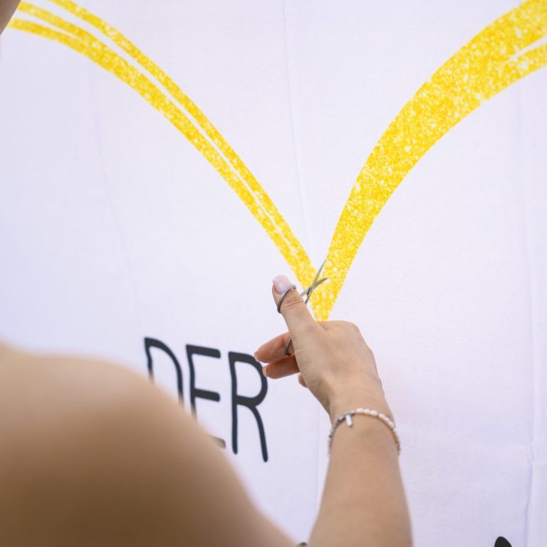 Tuch kurz bevor es durchgeschnitten wird Schere wird benutzt um das Tuch zu schneiden