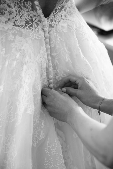 Beste Freundin knöpft der Braut das Kleid zu bei Hochzeit in Stuttgart – emotionales Getting Ready, inniger Moment vor der Trauung.