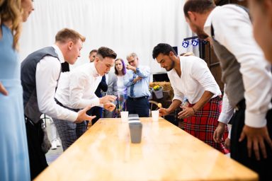 Lustige Hochzeitsparty in Karlsruhe – Gäste spielen Bierpong im Freien, lachen, jubeln und genießen lockere Stimmung bei der Hochzeitsfeier.