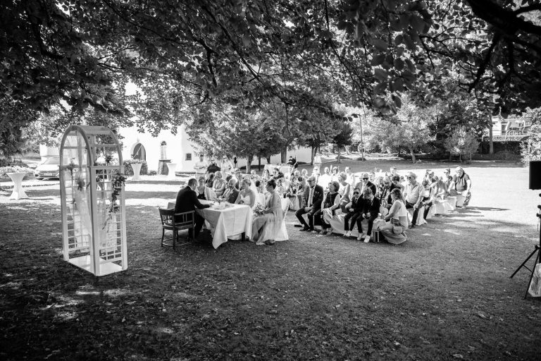 Glückliches Paar bei ihrer Hochzeit Weitwinkliges Bild während der Trauung in Schwarz Weiss
