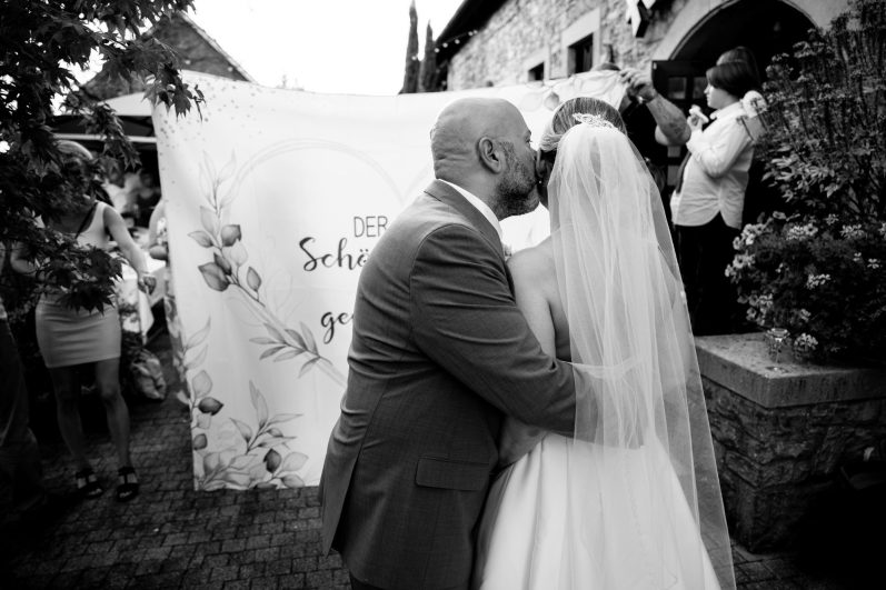 Ein Kuss auf die Backe der Braut Kuss bevor es zu einem Eventpunkt von der Hochzeit kommt