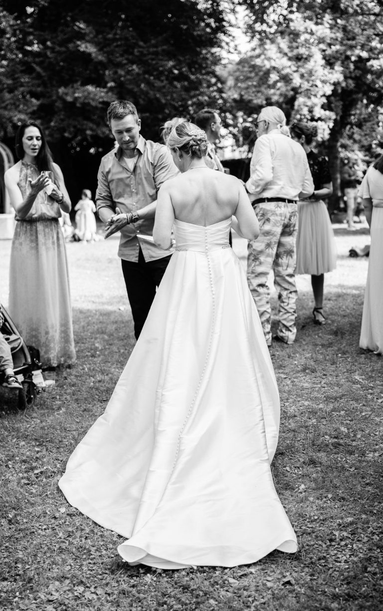 Brautkleid und Braut von hinten beim Sektempfang Die Braut von hinten fotografiert beim Sektempfang