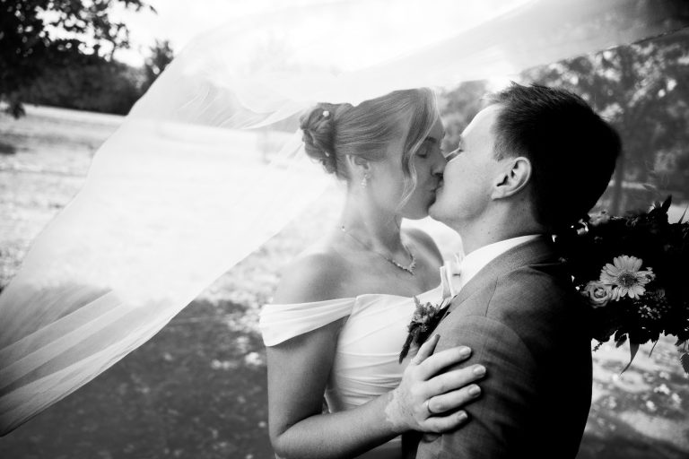 Der erste Kuss unter dem Schleier beim Hochzeitstag