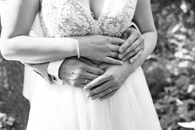 Detailfoto Eheringe vor Brautkleid bei Hochzeit in Stuttgart.