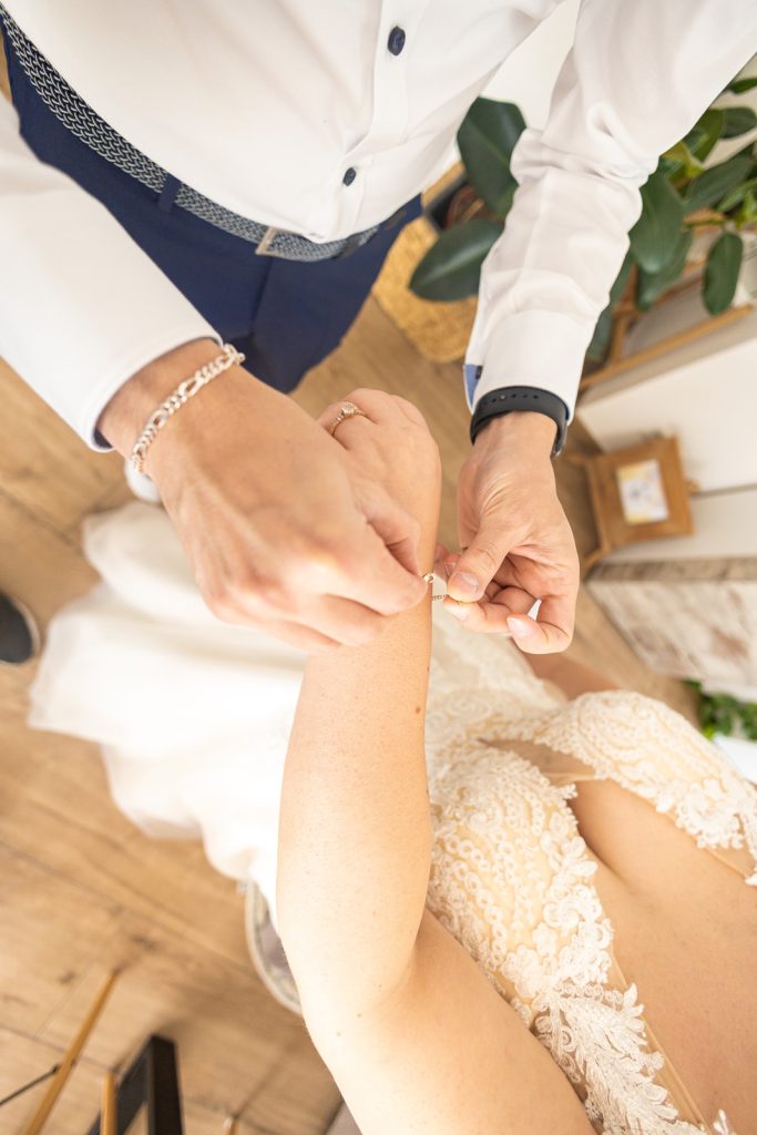 Hochzeit Heilbronn – Bester Freund zieht Braut Kette an Bester Freund legt Braut Kette an bei Hochzeit in Heilbronn – emotionales Getting Ready, inniger Moment beim Brautstyling.