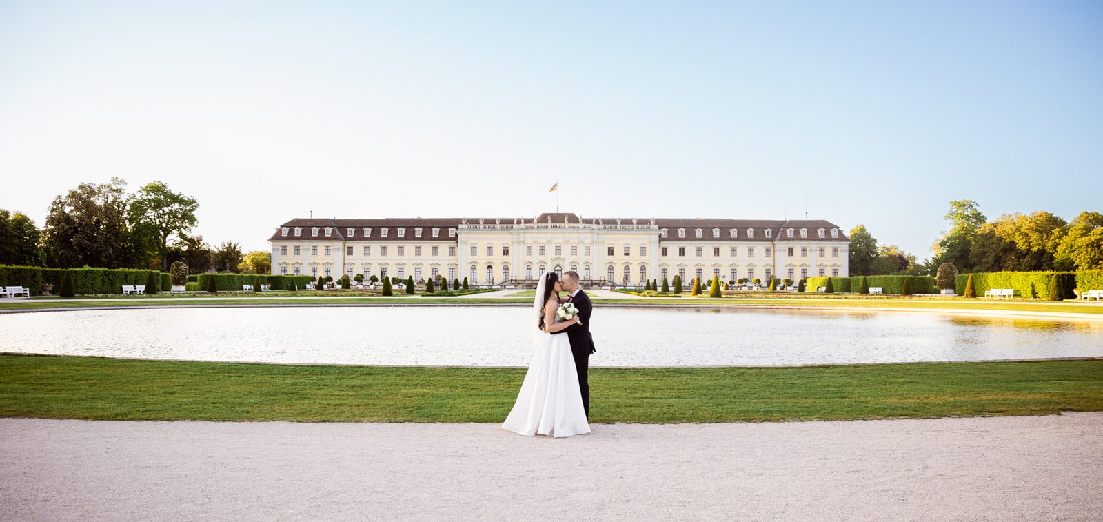 Romantisches Hochzeitspaar vor dem Residenzschloss Ludwigsburg Brautpaar posiert vor dem barocken Residenzschloss Ludwigsburg bei Sonnenuntergang