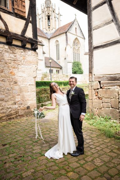 Lachendes Brautpaar in der Altstadt bei einem Kloster in Stuttgart.