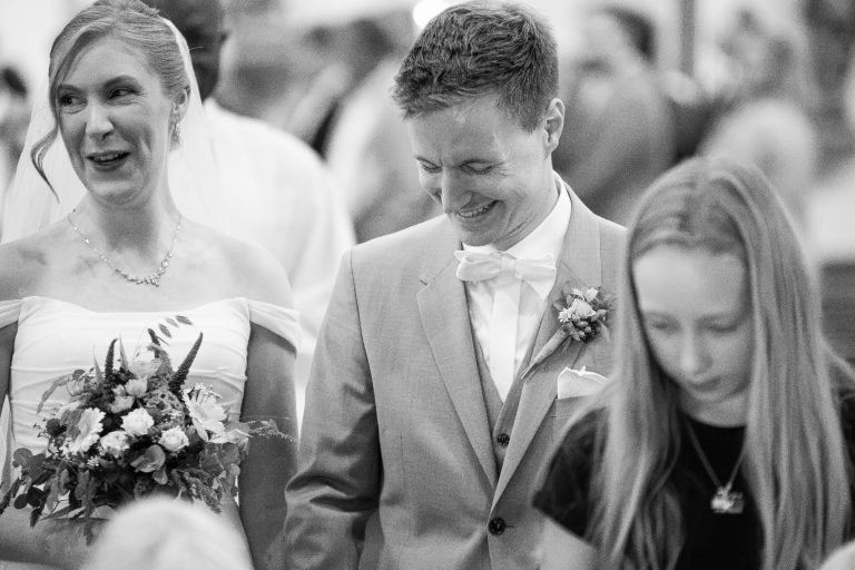 Das fröhliche Brautpaar marschiert die Kirche raus bei der Hochzeit