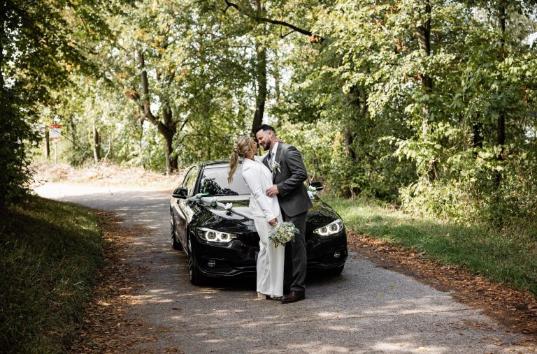 Gloria & Samuel vor dem Auto an ihrer Hochzeit Echte Aufnahme eines Brautpaar in Güglingen, Kraichgau und ganz Heilbronn