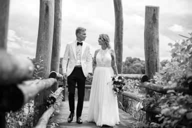 Brautpaar läuft Hand in Hand auf Steg bei Hochzeit in Stuttgart.